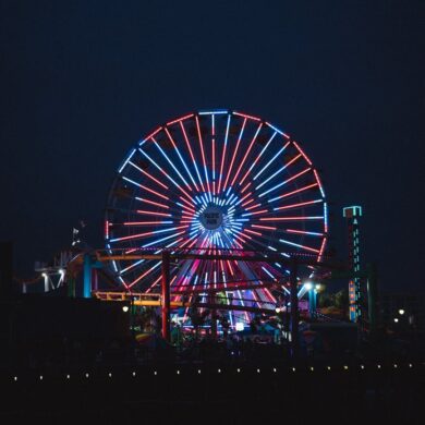 illuminated ferris wheel in amusement park at night