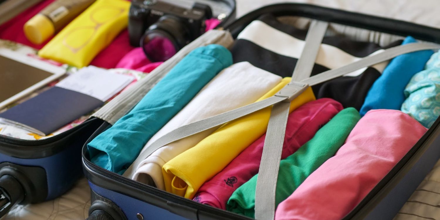 blue luggage with folded clothes